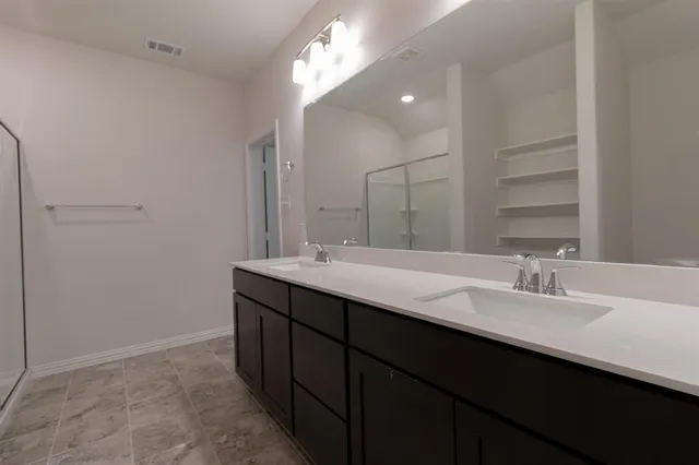 a bathroom with a double vanity sink and a mirror