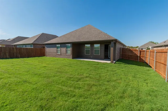a view of a house with a yard and a large tree