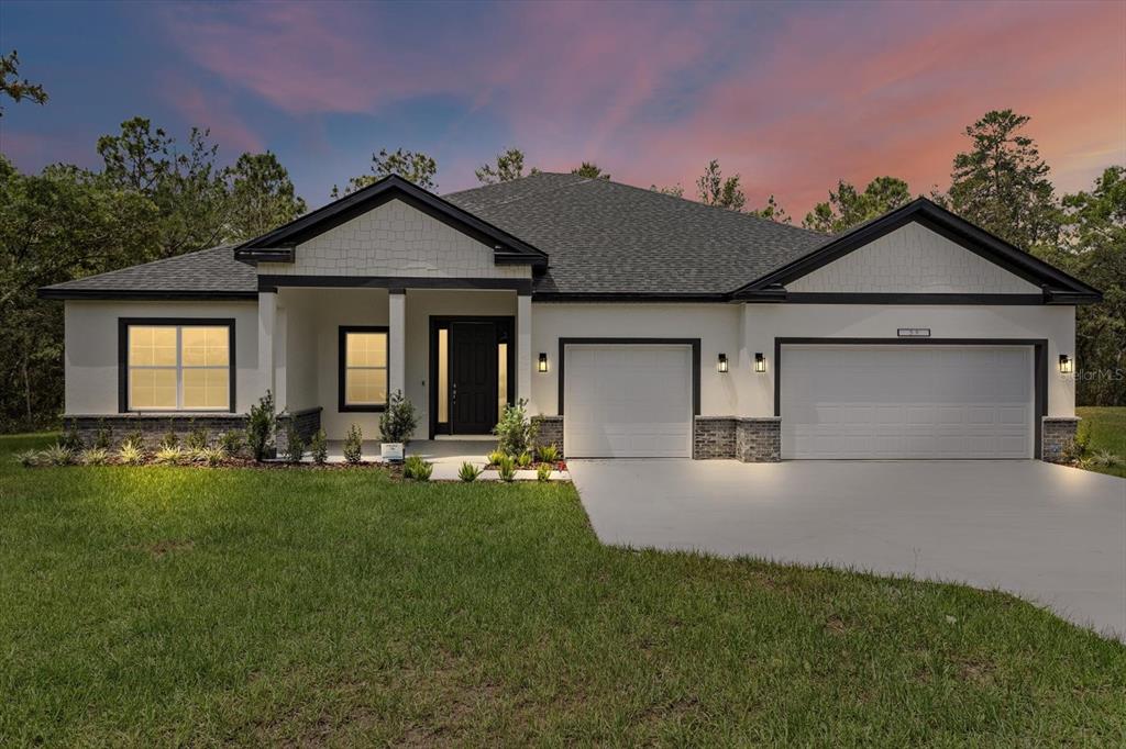 7689 Southwest 129th Place Ocala, FL 34473 - Photo 1 of 1 a front view of a house with a garden and yard