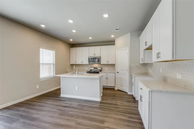 a kitchen with a white wooden floor and window
