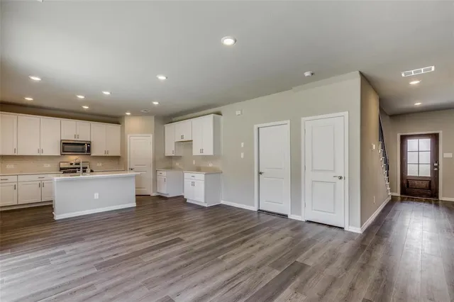 a view of kitchen with wooden floor and electronic appliances