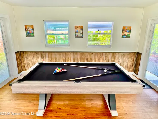 a room with pool table and windows