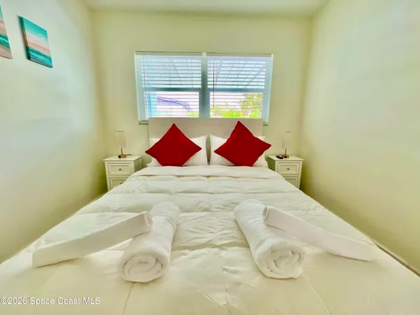 a large bed sitting in a bedroom next to a window