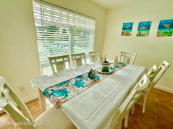 a dining room with furniture and a large window
