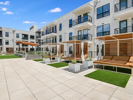 a front view of a building with outdoor seating and plants
