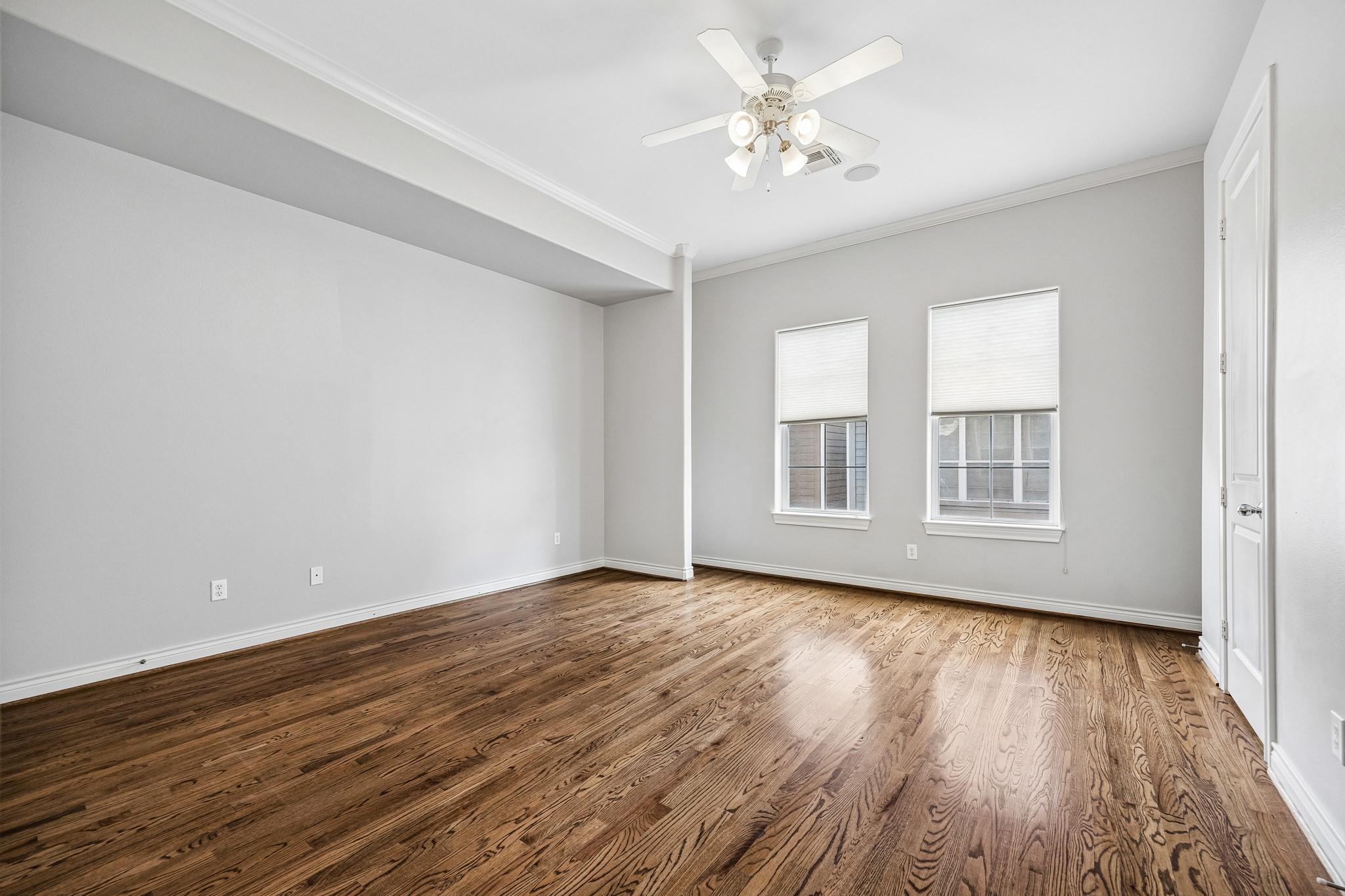 622 Rutland Street, Unit D Houston, TX 77007 - Photo 12 of 27 Spacious primary bedroom with hardwood flooring and a neutral color palette. Multiple windows allow for great natural light while maintaining privacy. Generous layout offers flexibility for a variety of furniture arrangements.