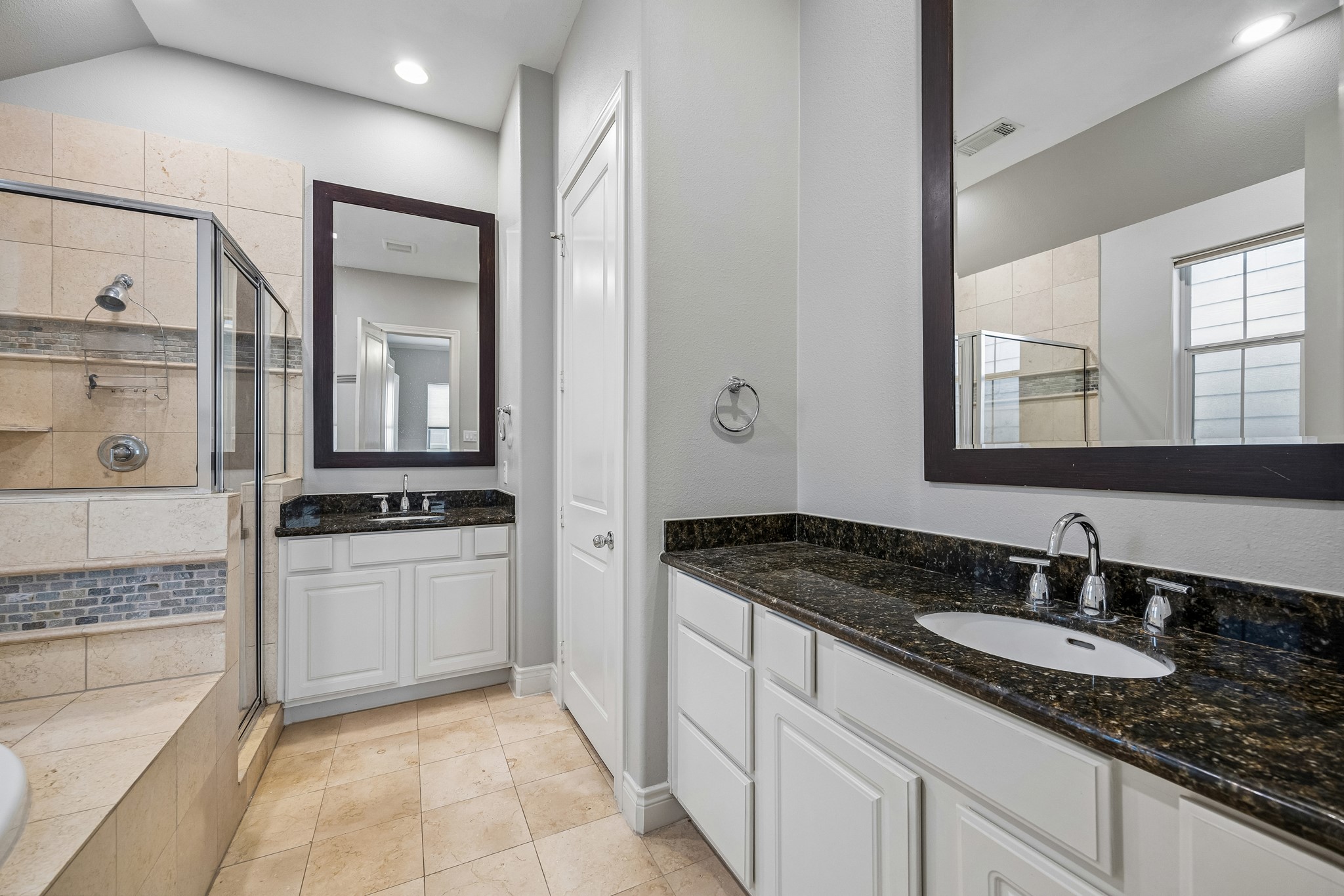622 Rutland Street, Unit D Houston, TX 77007 - Photo 14 of 27 Dual vanity layout in the primary bathroom offers ample storage and counter space. Granite countertops and framed mirrors add a polished touch. Bright and well-lit for daily convenience.