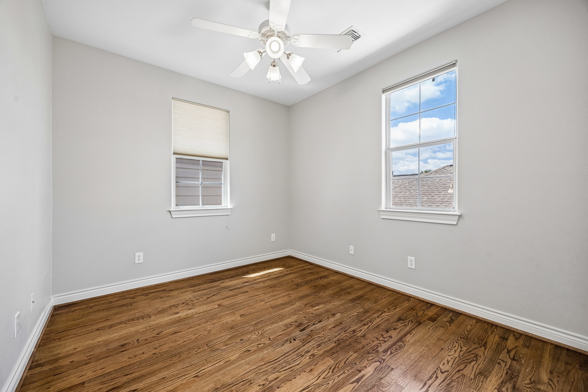 622 Rutland Street, Unit D Houston, TX 77007 - Photo 15 of 27 Secondary bedroom with hardwood floors and large windows for natural light. Neutral tones create a bright and airy feel. Ideal for guests, home office, or flex space.