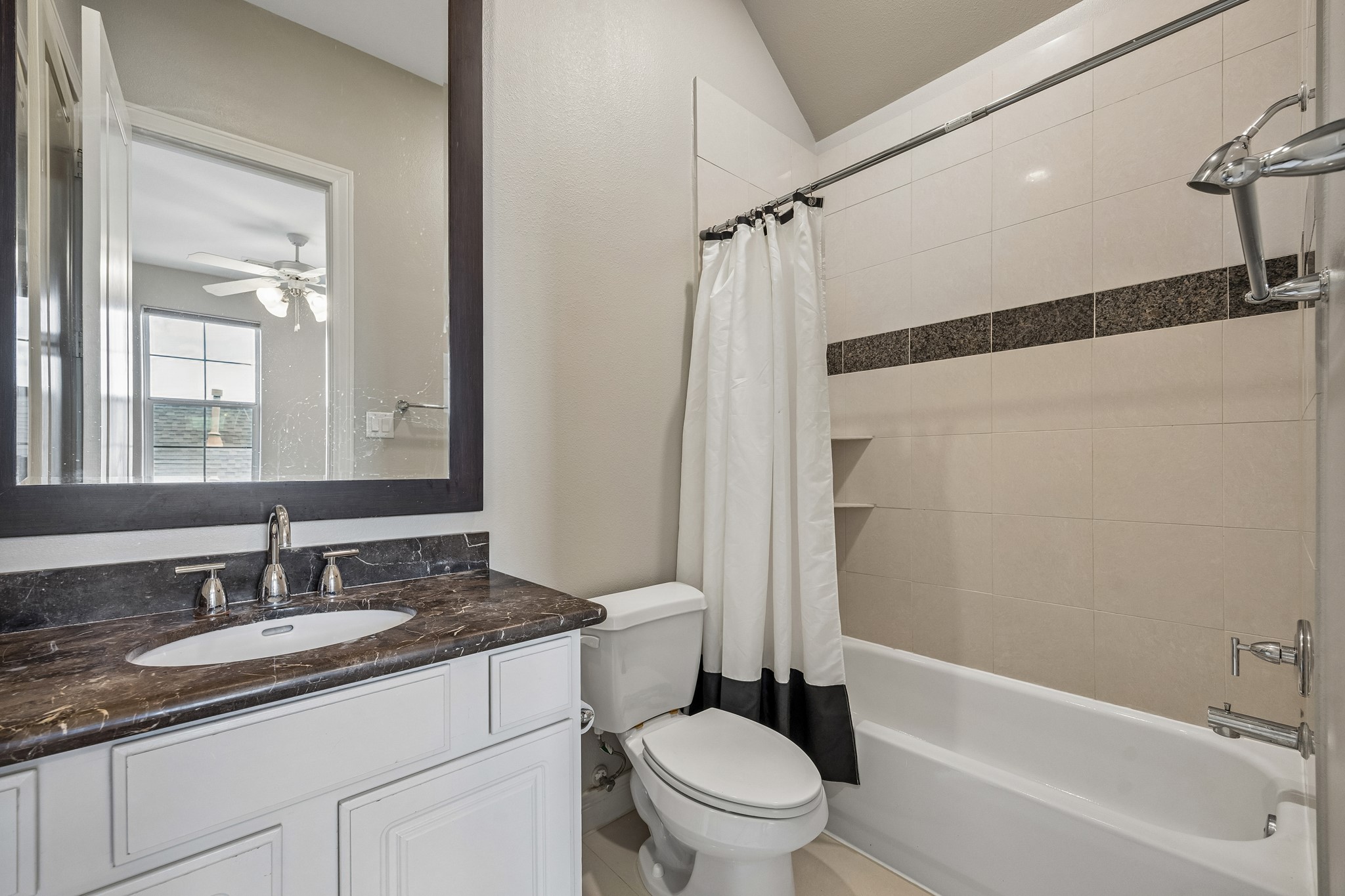 622 Rutland Street, Unit D Houston, TX 77007 - Photo 18 of 27 Full bathroom featuring granite countertops, framed mirror, and tiled tub/shower combo. Clean finishes and functional design make it ideal for guests or secondary bedrooms.