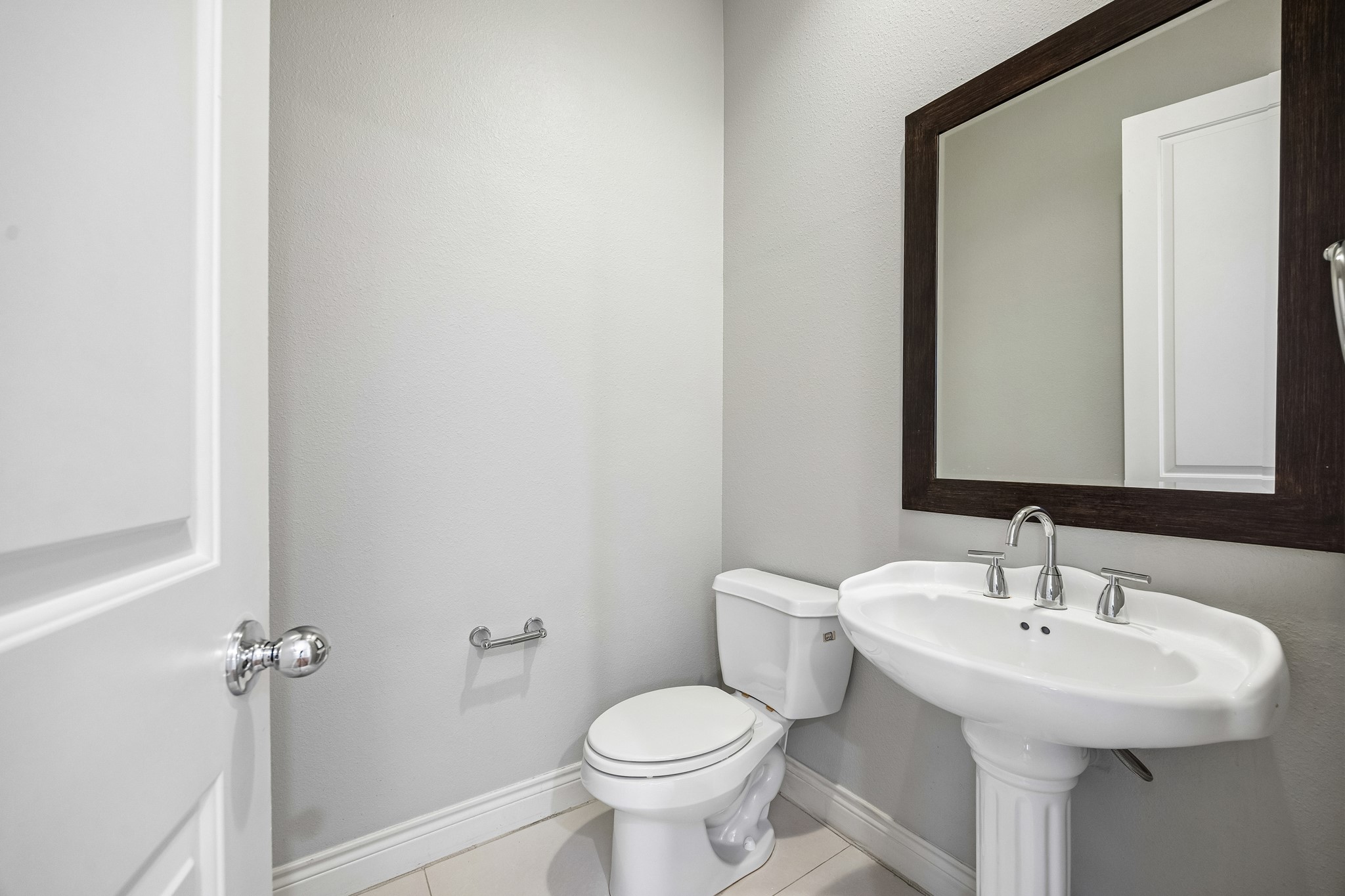 622 Rutland Street, Unit D Houston, TX 77007 - Photo 19 of 27 Convenient powder bath with pedestal sink and framed mirror. Clean, classic finishes make it perfect for guests. Easily accessible from main living areas.