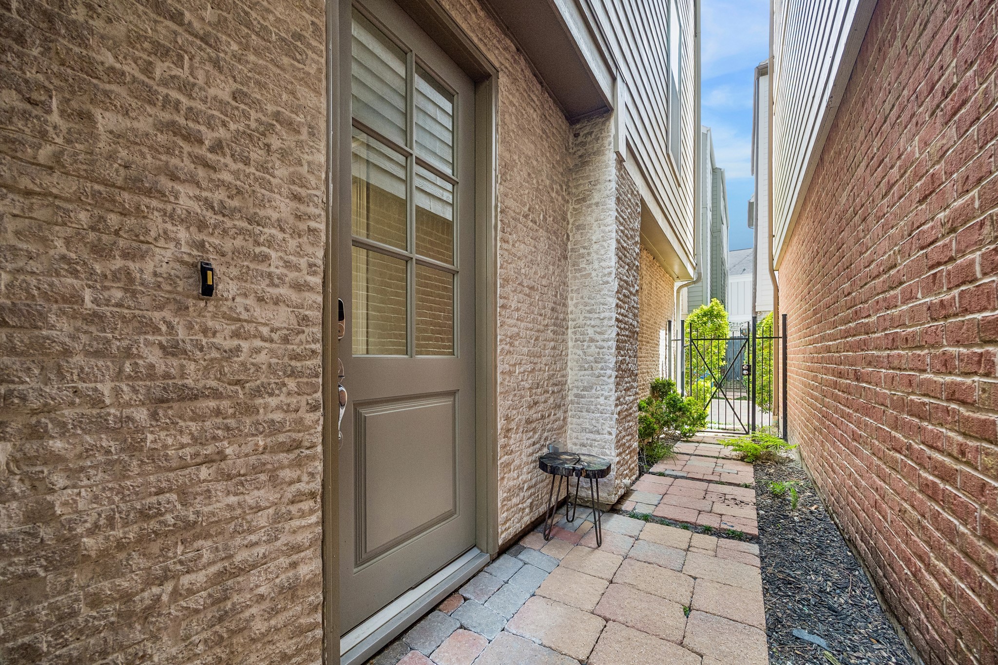 622 Rutland Street, Unit D Houston, TX 77007 - Photo 2 of 27 Private side entry with brick and stone exterior detailing. Gated access provides added security and a tucked-away feel. Low-maintenance walkway enhances everyday convenience.