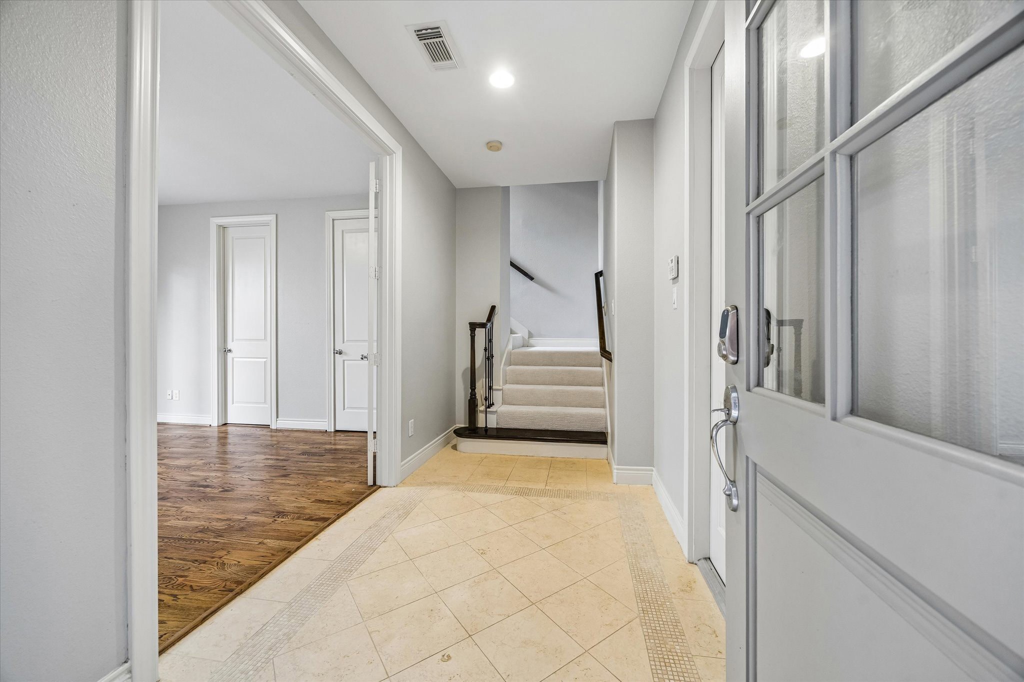 622 Rutland Street, Unit D Houston, TX 77007 - Photo 3 of 27 Inviting entry with tile flooring and neutral paint palette. Functional layout includes easy access to secondary rooms and staircase. Clean lines and natural light create a bright first impression.