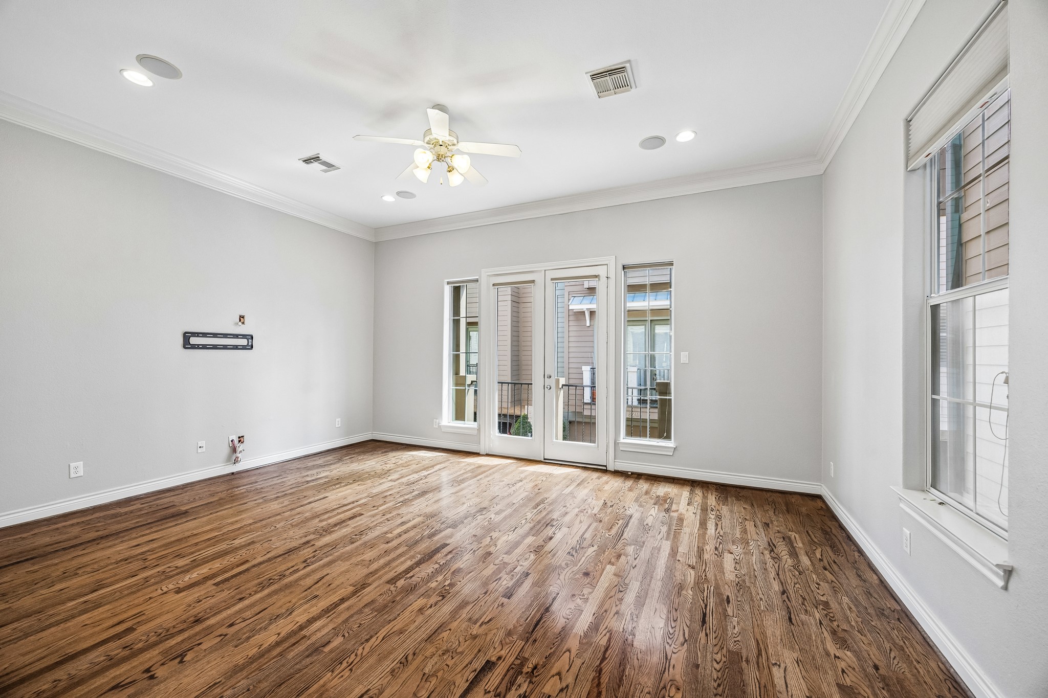 622 Rutland Street, Unit D Houston, TX 77007 - Photo 5 of 27 Spacious living area featuring rich hardwood floors, crown molding, and abundant natural light. French doors lead to a private balcony, perfect for indoor-outdoor living. Open layout offers flexibility for entertaining and everyday living.