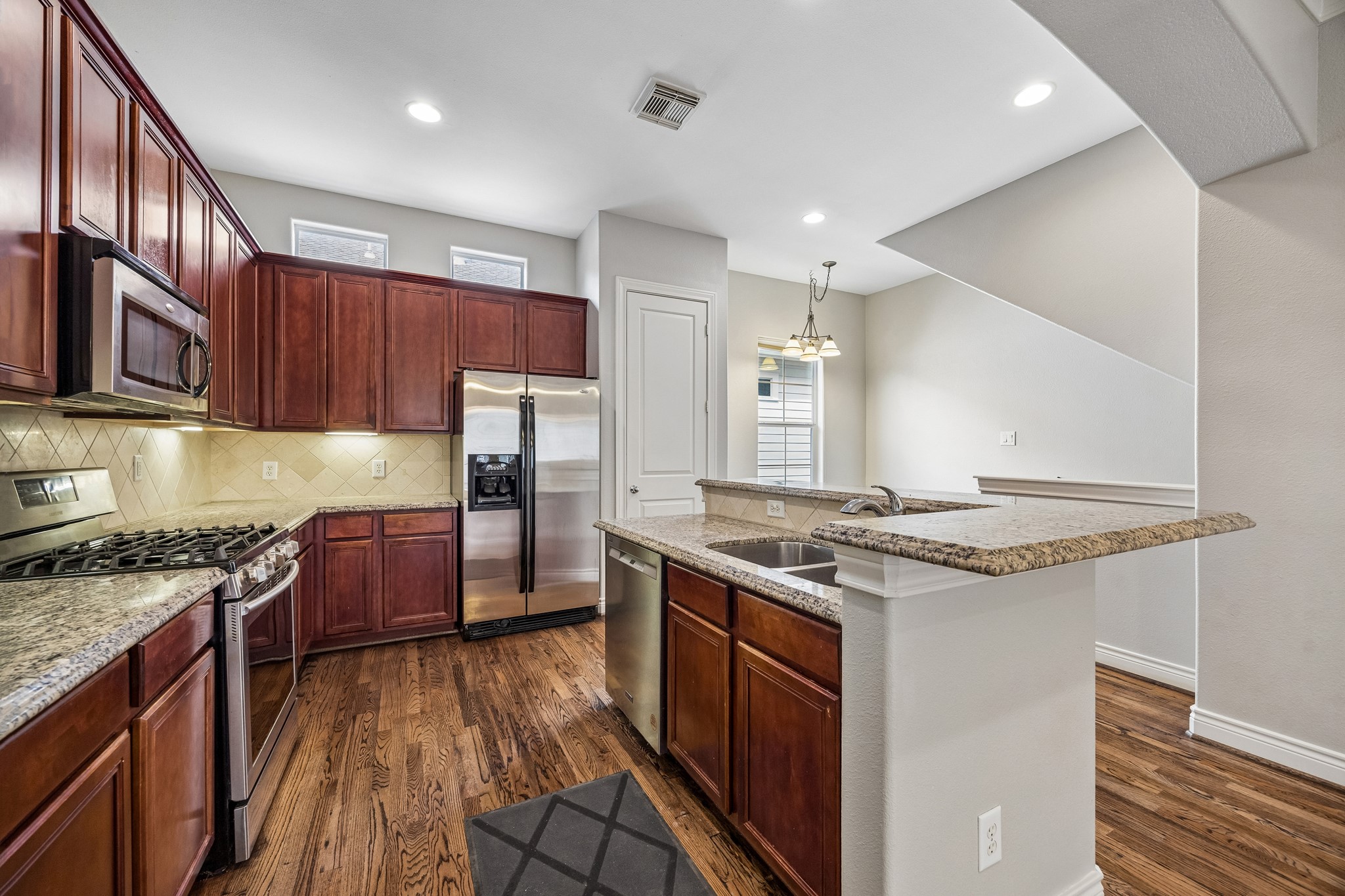622 Rutland Street, Unit D Houston, TX 77007 - Photo 6 of 27 Well-appointed kitchen with granite countertops, stainless steel appliances, and ample cabinetry. Breakfast bar and open layout make it ideal for entertaining. Under-cabinet lighting and tile backsplash add warmth and functionality.