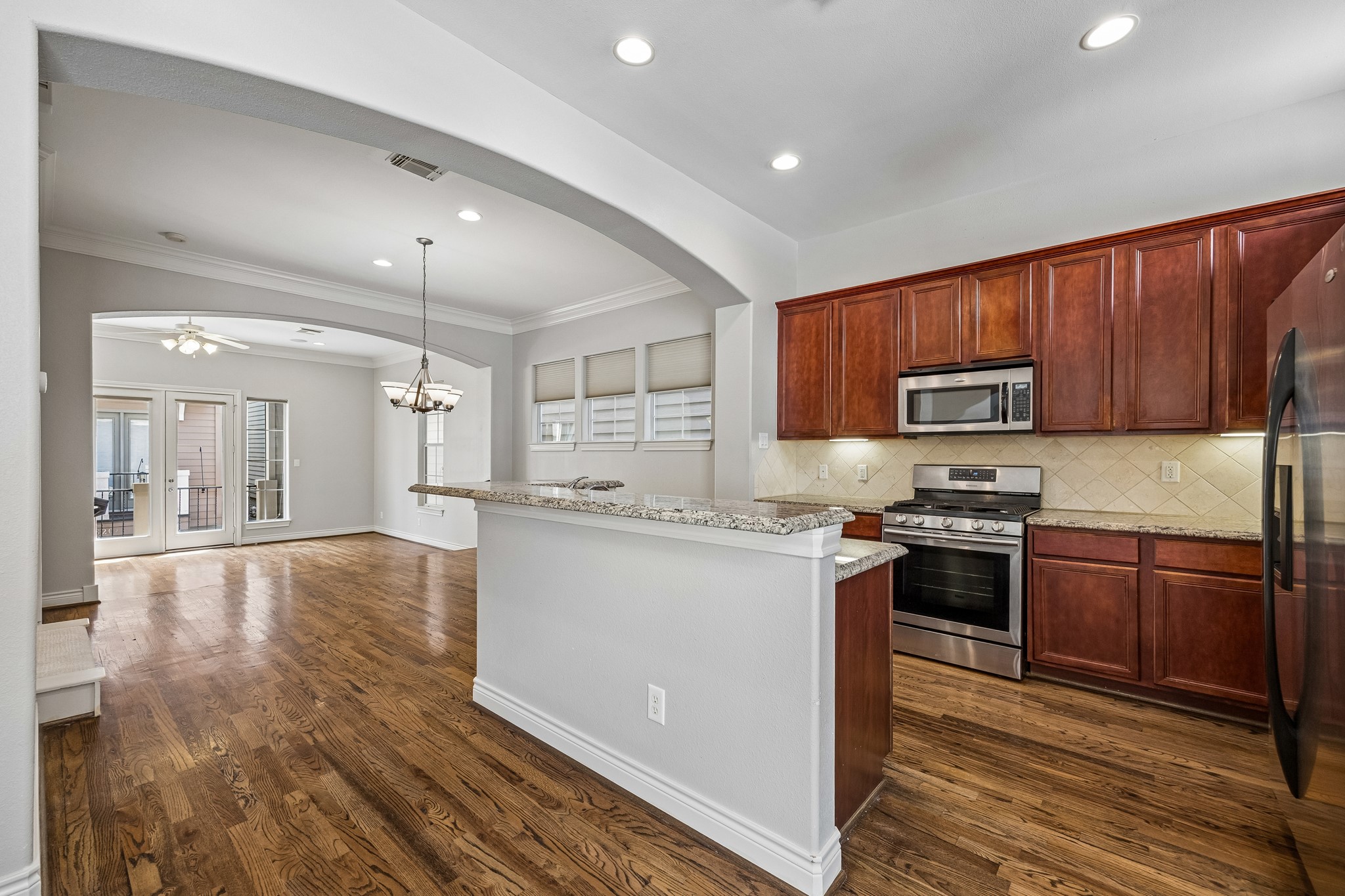 622 Rutland Street, Unit D Houston, TX 77007 - Photo 8 of 27 Well-designed kitchen featuring granite countertops, stainless steel appliances, and abundant cabinetry. Raised breakfast bar provides additional seating and workspace. Open sightlines to the living and dining areas enhance the flow.