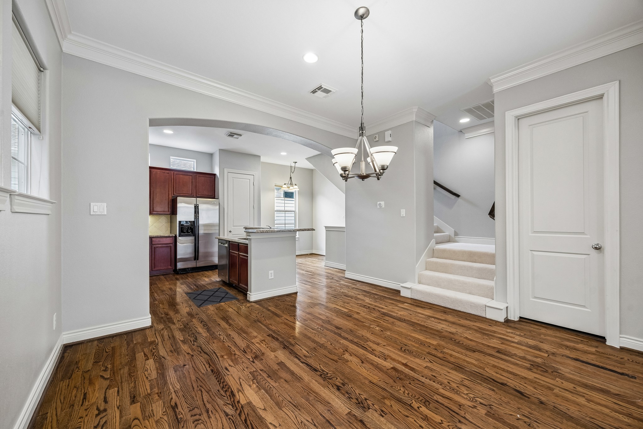 622 Rutland Street, Unit D Houston, TX 77007 - Photo 10 of 27 Bright dining area positioned between the living room and kitchen. Stylish chandelier and crown molding elevate the space. Perfect for both casual meals and formal gatherings.