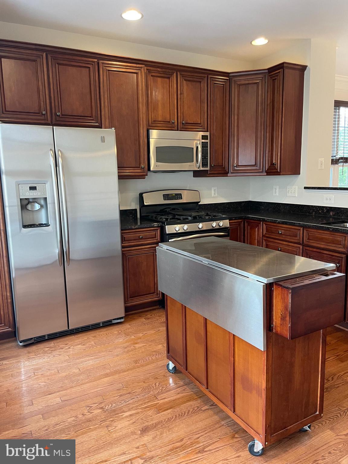25111 Monteith Terrace Chantilly, VA 20152 - Photo 4 of 34 a kitchen with wooden cabinets and stainless steel appliances