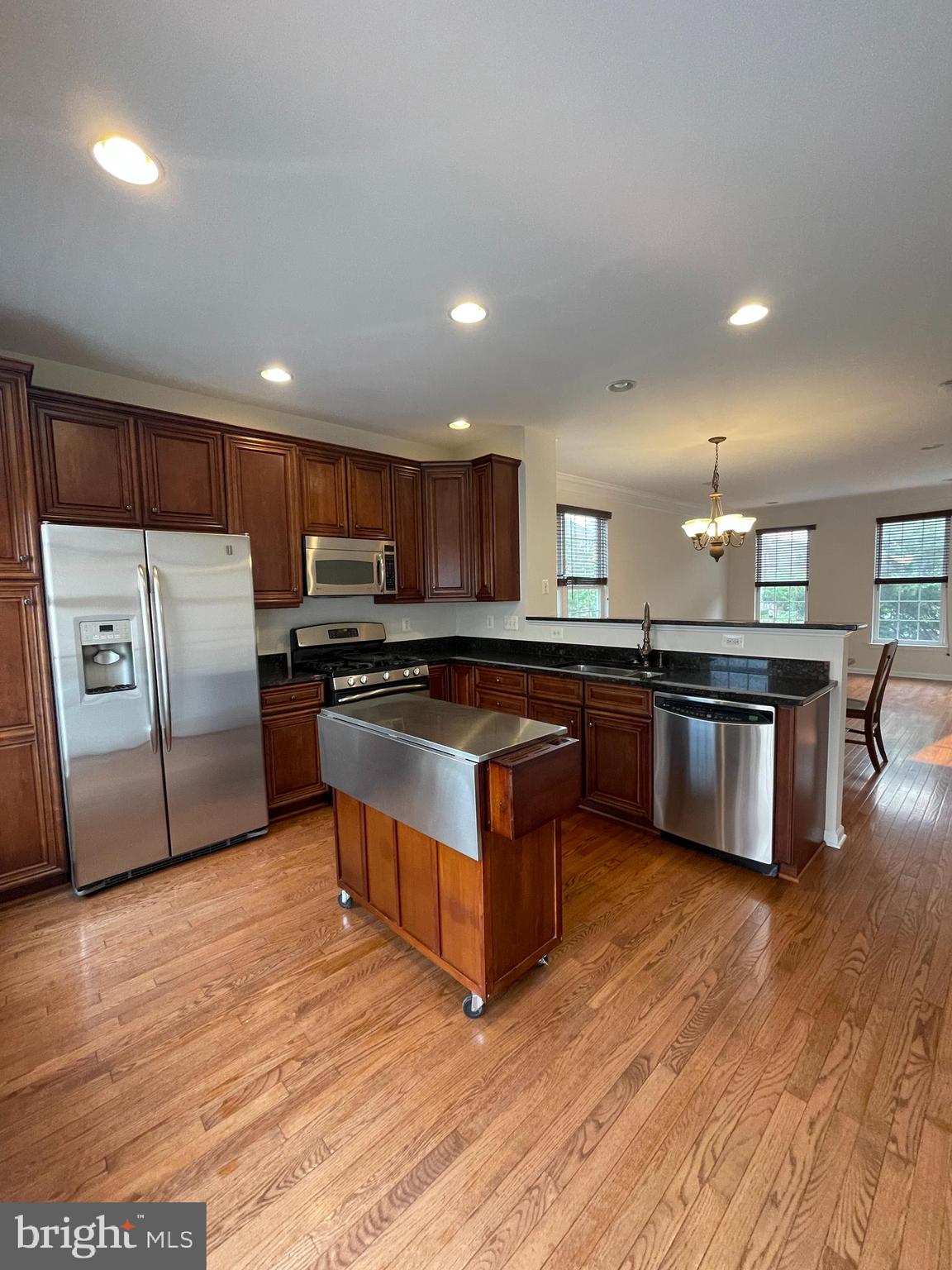 25111 Monteith Terrace Chantilly, VA 20152 - Photo 5 of 34 a kitchen with stainless steel appliances granite countertop a refrigerator a sink a stove a microwave and island