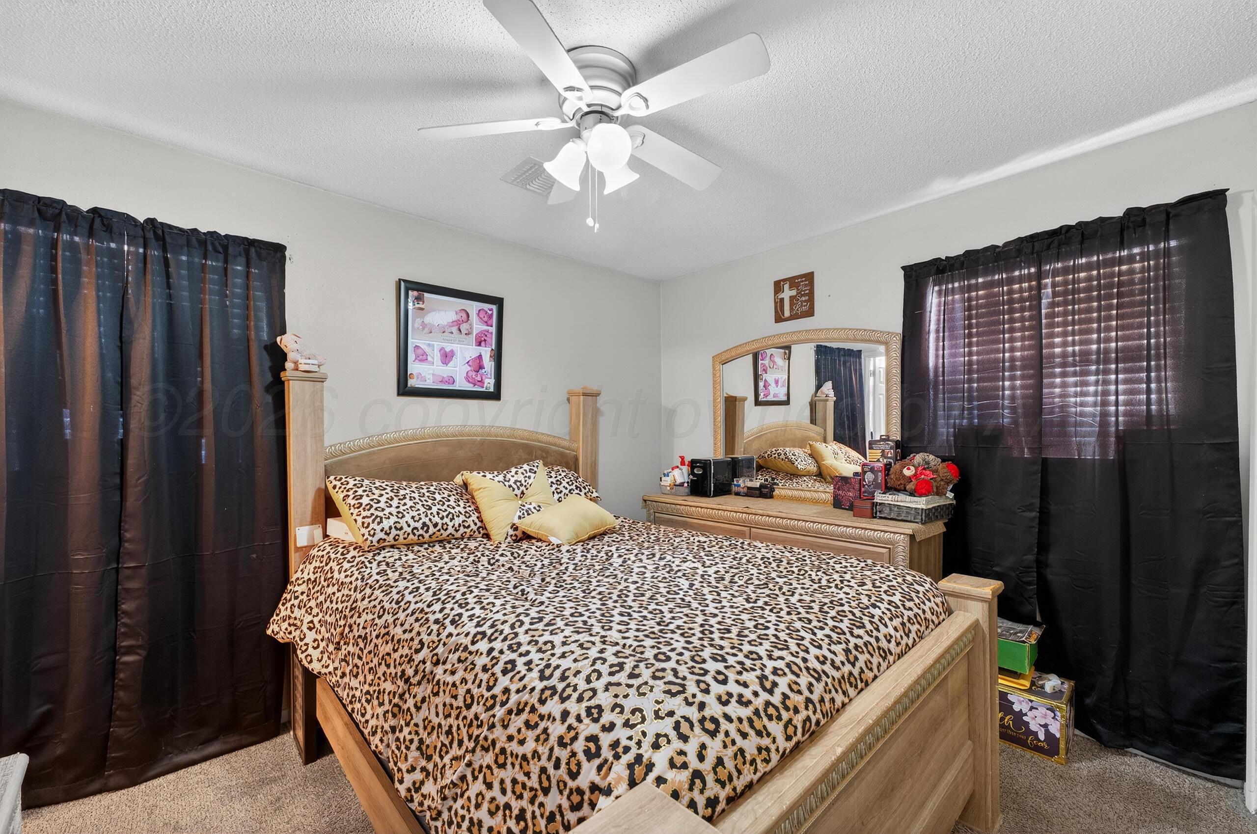 1007 Tudor Drive Amarillo, TX 79104 - Photo 13 of 27 a bedroom with a bed and a table in it