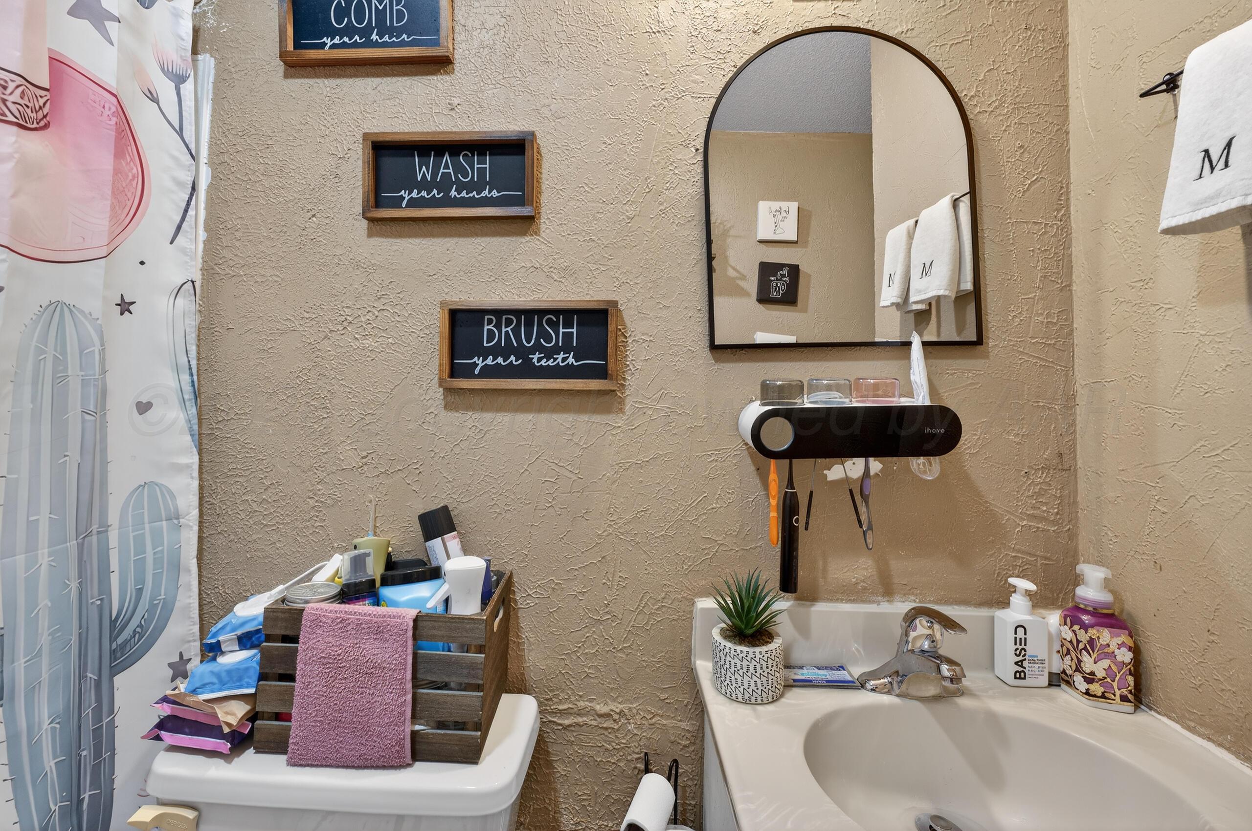 1007 Tudor Drive Amarillo, TX 79104 - Photo 16 of 27 a bathroom with a toilet sink and mirror