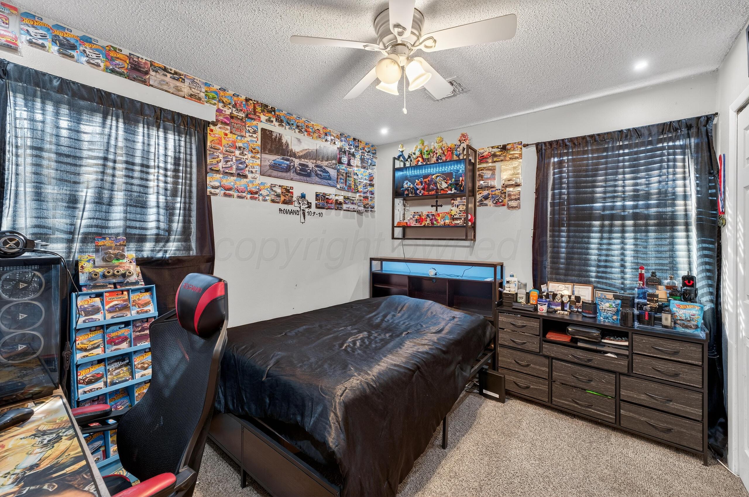 1007 Tudor Drive Amarillo, TX 79104 - Photo 23 of 27 a bedroom with a bed and a chandelier