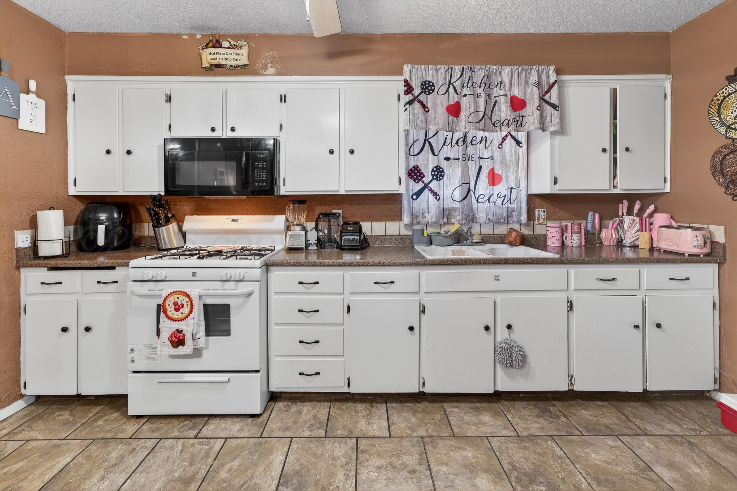 1007 Tudor Drive Amarillo, TX 79104 - Photo 7 of 27 a view of cabinets with stainless steel appliances granite countertop a stove a sink and dishwasher