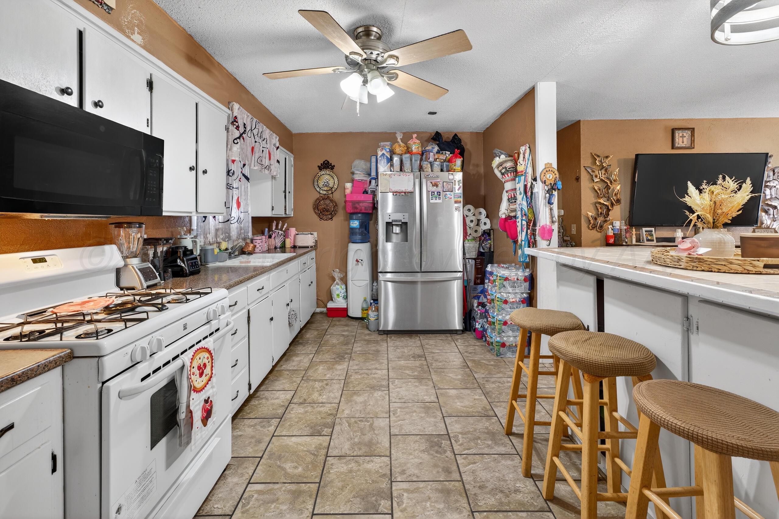 1007 Tudor Drive Amarillo, TX 79104 - Photo 10 of 27 a kitchen that has a lot of white cabinets and stainless steel appliances