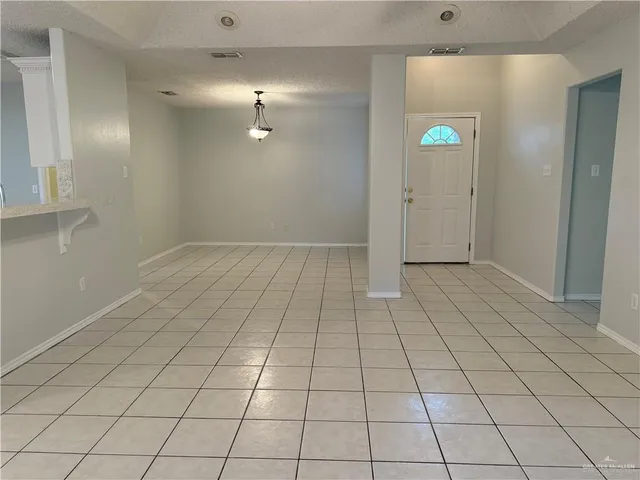 a view of an empty room with a chandelier fan