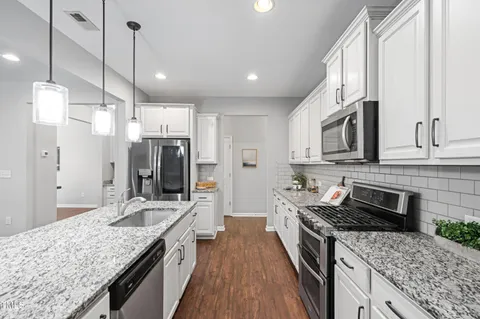 a kitchen with stainless steel appliances granite countertop a sink stove and refrigerator