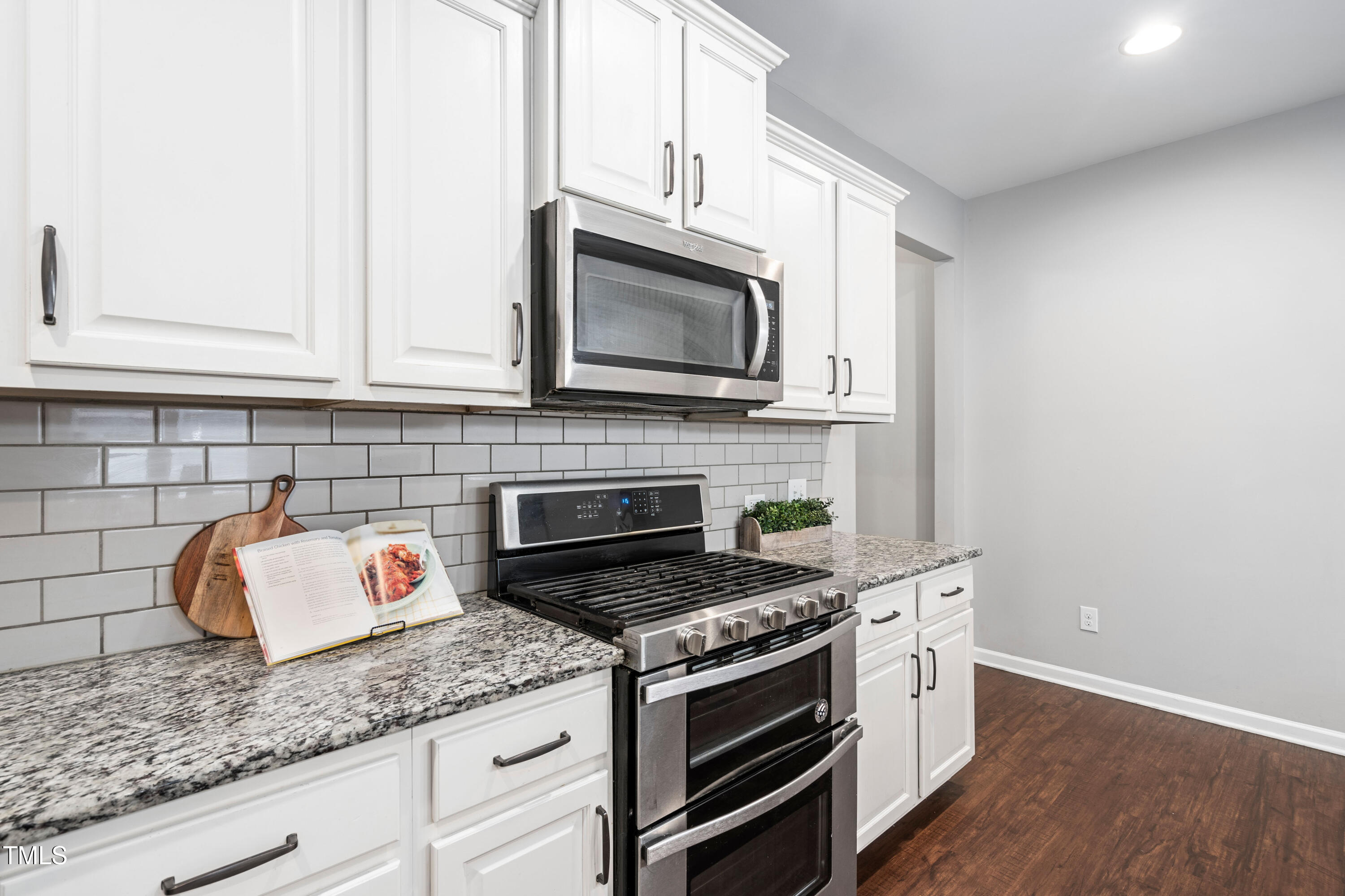 624 Metro Station Apex, NC 27502 - Photo 7 of 36 a kitchen with granite countertop cabinets stainless steel appliances and wooden floor