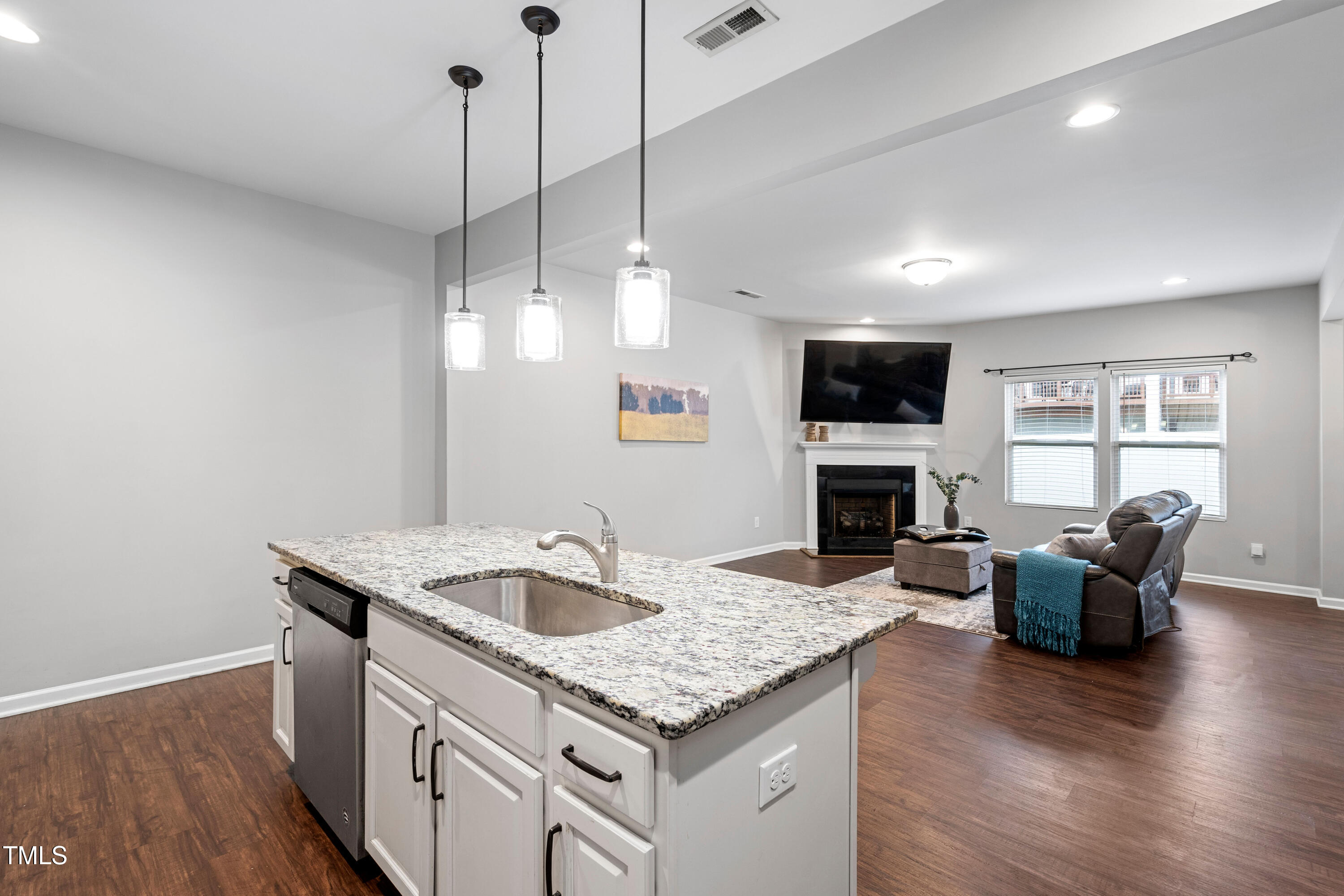 624 Metro Station Apex, NC 27502 - Photo 8 of 36 a kitchen with kitchen island granite countertop a sink cabinets and wooden floor