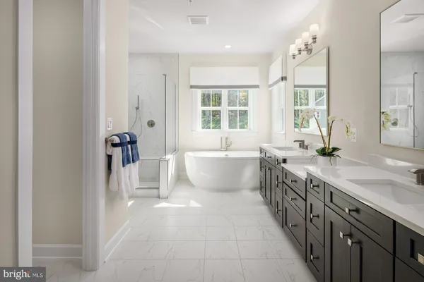 a spacious bathroom with a double vanity sink a mirror and a bathtub