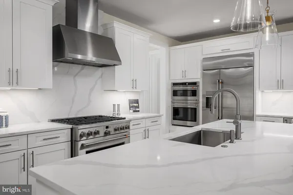 a kitchen with stainless steel appliances kitchen island a stove and a sink