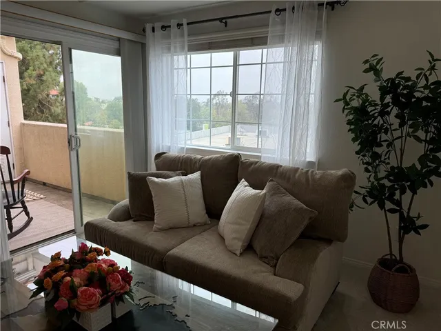 a living room with furniture and a floor to ceiling window