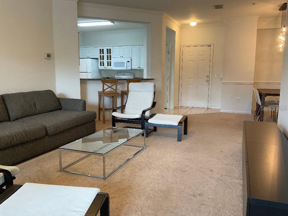 3701 Conroy Road, Unit 1822 Orlando, FL 32839 - Photo 3 of 23 a living room with furniture and a wooden floor