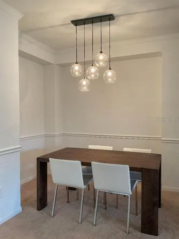 a view of a dining room with furniture and chandelier