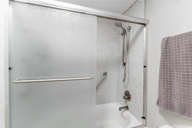 a bathroom with a shower and a glass shower door
