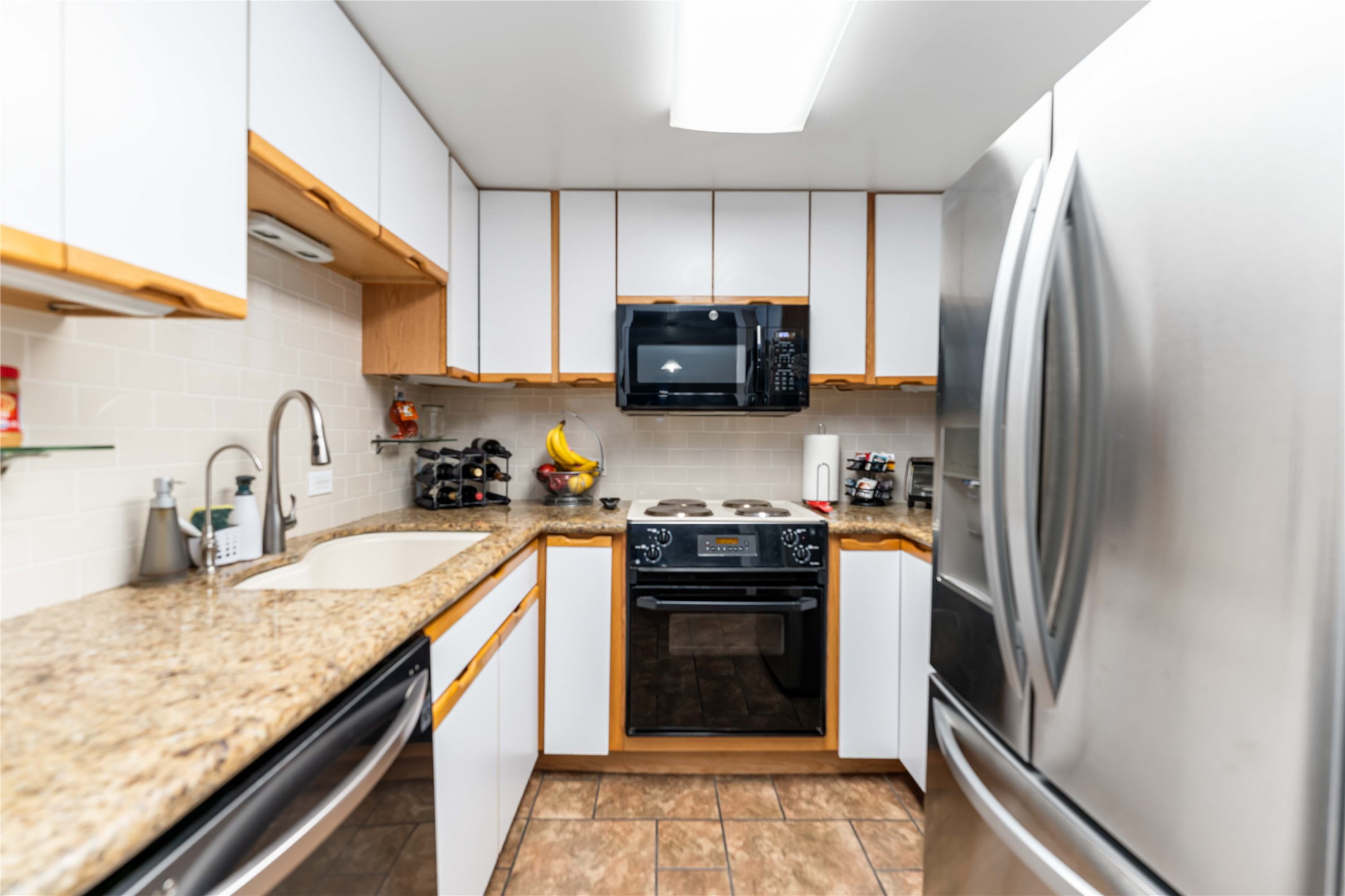 2016 Main Street, Unit 2305 Houston, TX 77002 - Photo 8 of 26 a kitchen with granite countertop a refrigerator stove and sink