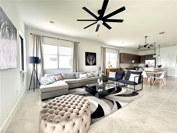 a living room with lots of furniture and view of kitchen