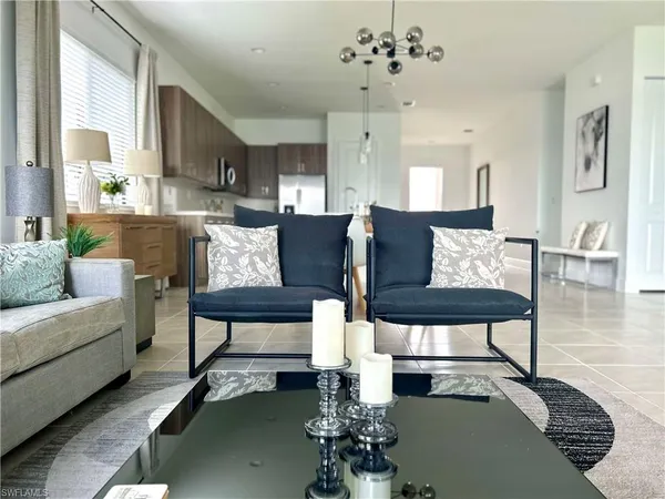 a living room with furniture a table and kitchen view