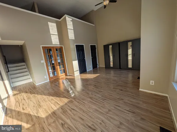 a view of a living room with wooden floor and stairs