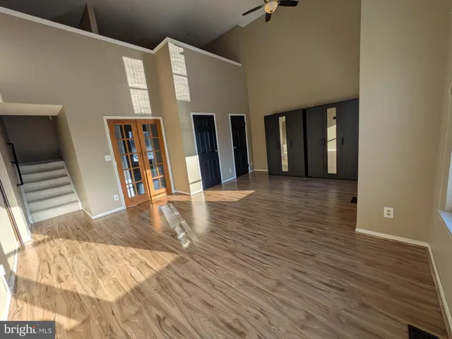 a view of a living room with wooden floor and stairs