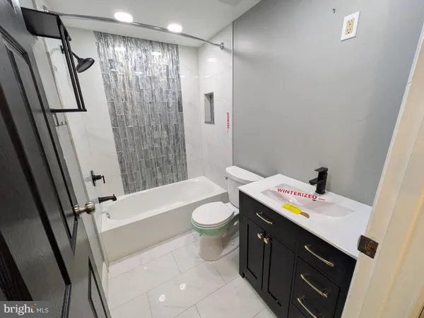a bathroom with a sink a toilet a tub and shower
