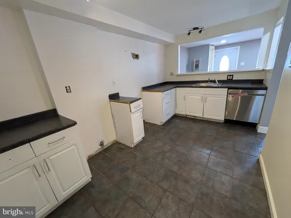 a large kitchen with a sink and cabinets
