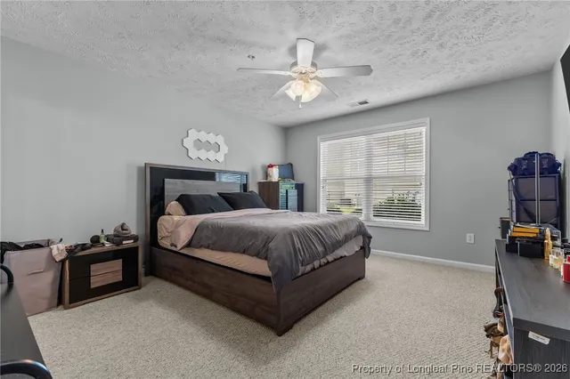 a spacious bedroom with a bed and a chandelier