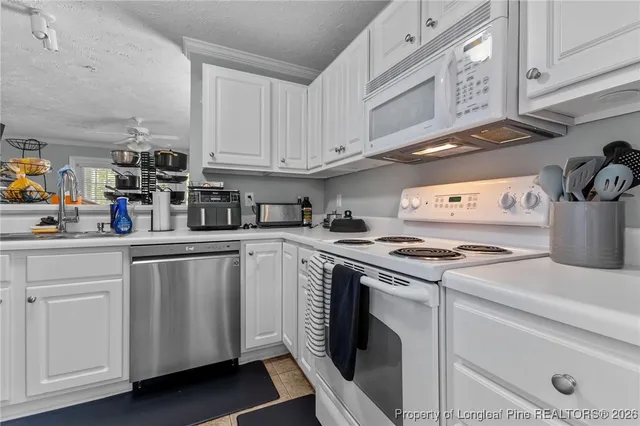 a kitchen with appliances a sink and cabinets