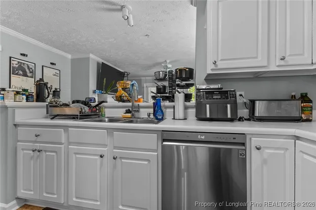 a kitchen with white cabinets and sink