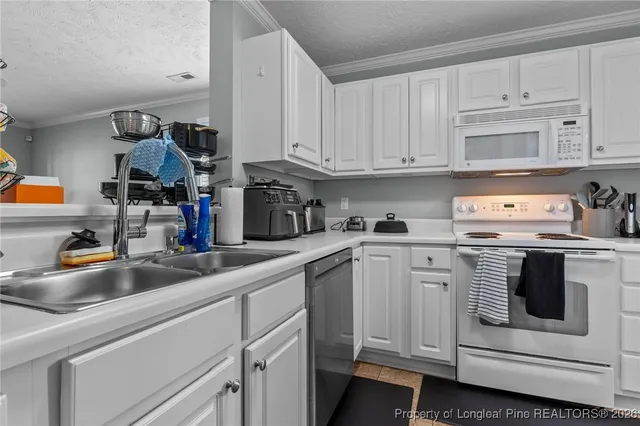 a kitchen with white cabinets and white appliances