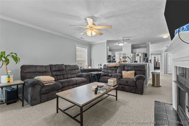 a living room with furniture a fireplace and a chandelier