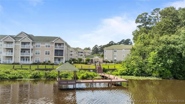a front view of a house with a garden and lake view